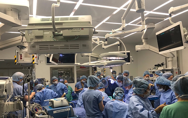 Group of people in surgical gear in an operating theater performing surgery 