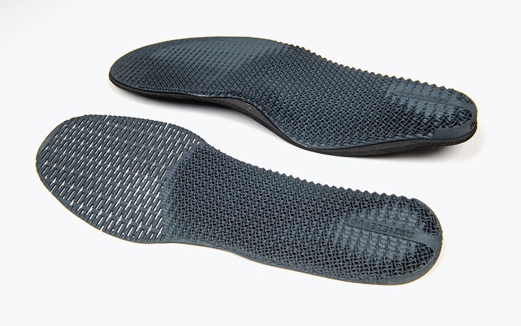 Two custom, 3D-printed insoles side by side, one with more support than the other