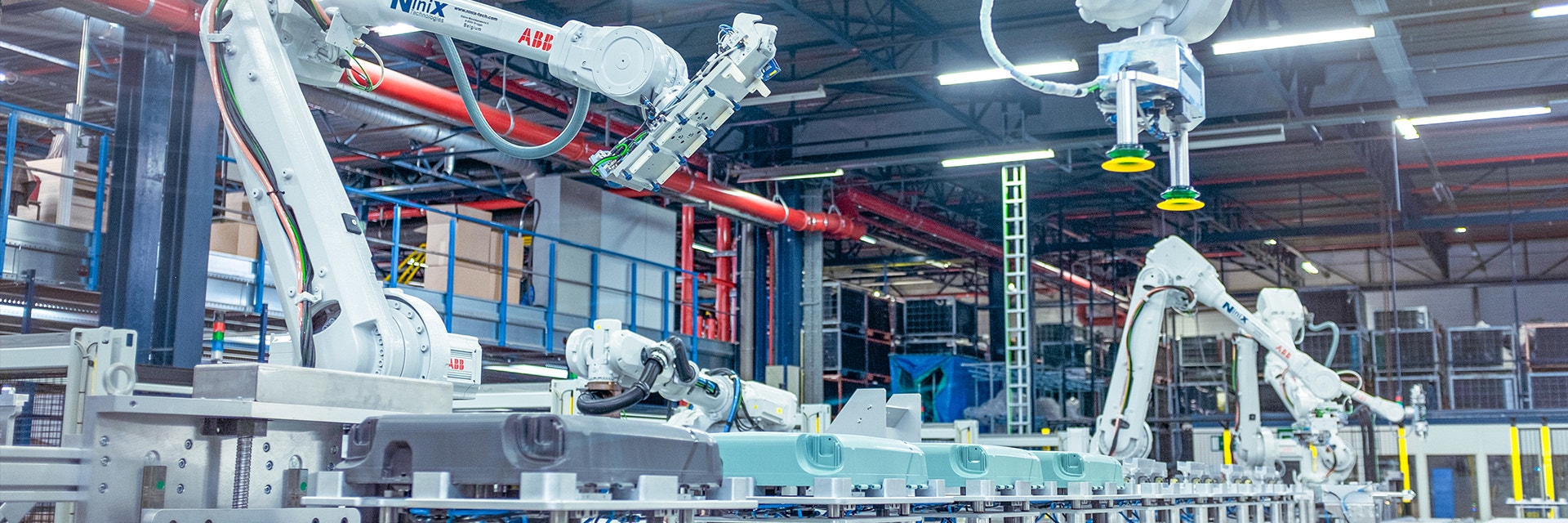 A series of Samsonite suitcases are being assembled on a production line by large ABB robots.