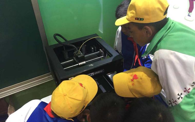 School children looking at a 3D printers