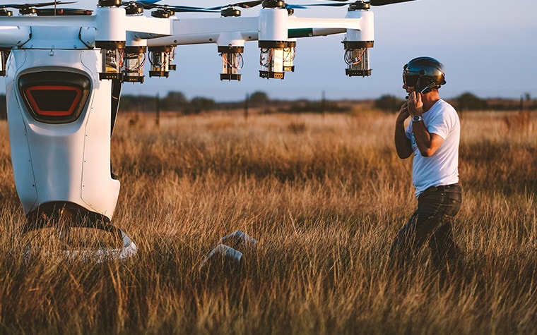 Ein Mann setzt auf einem Feld einen Helm auf, um an Bord des LIFT-Flugzeugs zu gehen