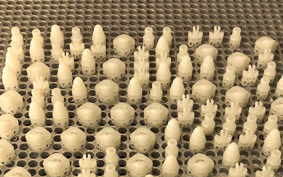 Rows of 3D-printed medical parts on a grate