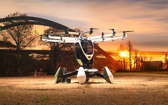 LIFT's HEXA aircraft landed in front of a bridge with a sunset in the background