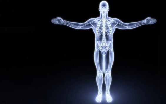 Image of a person standing with their arms spread and their skeleton glowing through