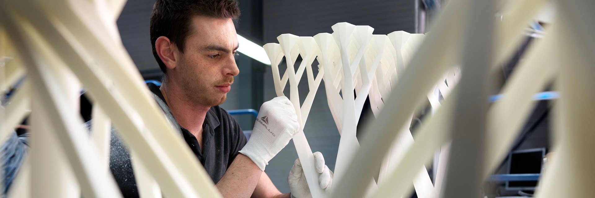 Hombre lijando una mesa impresa en 3D durante la postproducción