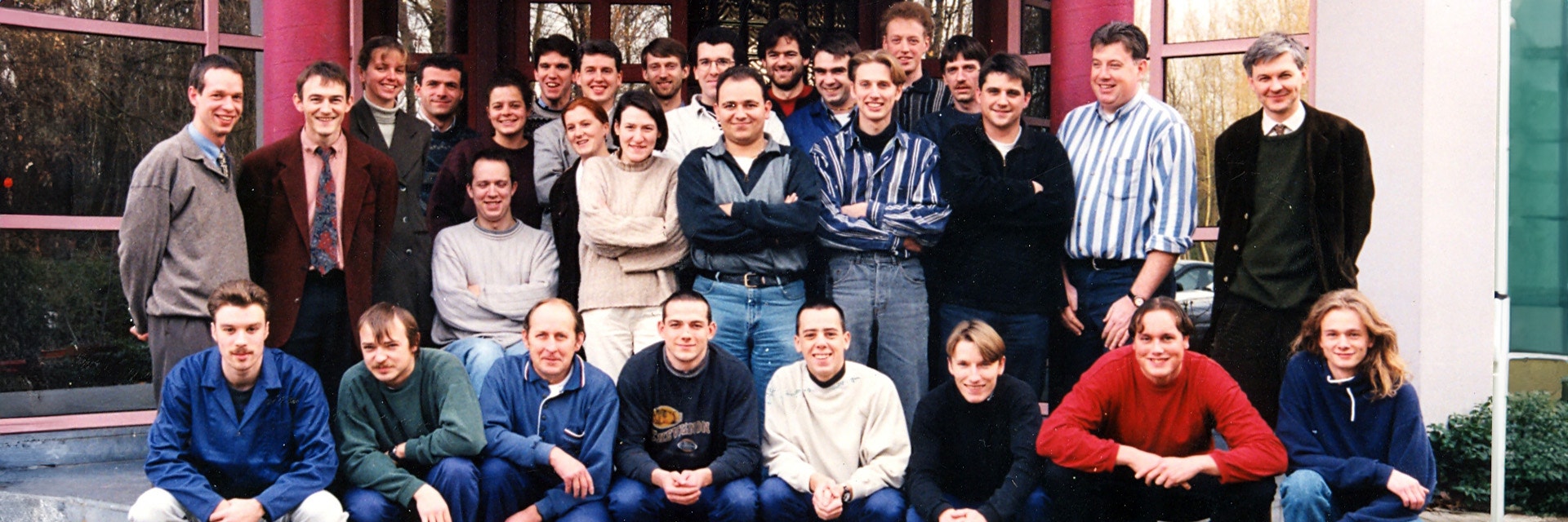 A group photo of Materialise's first set of employees standing outside