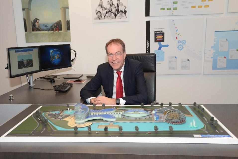 Man sitting at a desk with a 3D-printed artchitectural model