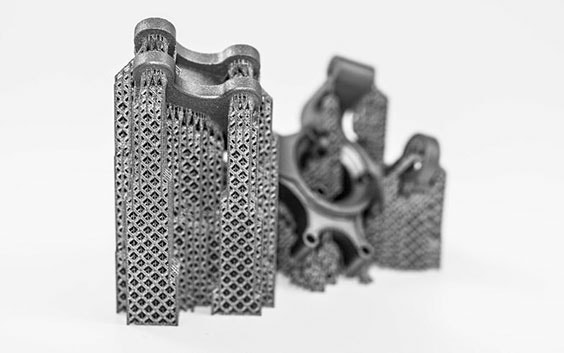 Pieza metálica impresa en 3D con las estructuras de soporte destacadas