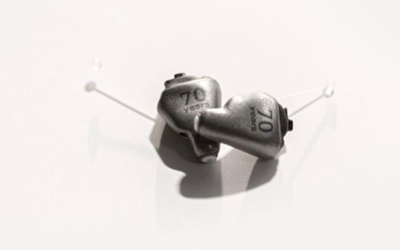 Metal 3D-printed hearing aids with '70 years' etched in the material