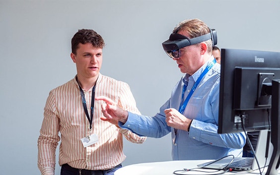 Man testing out augmented reality for medical purposes with the assistance of a Materialise employee