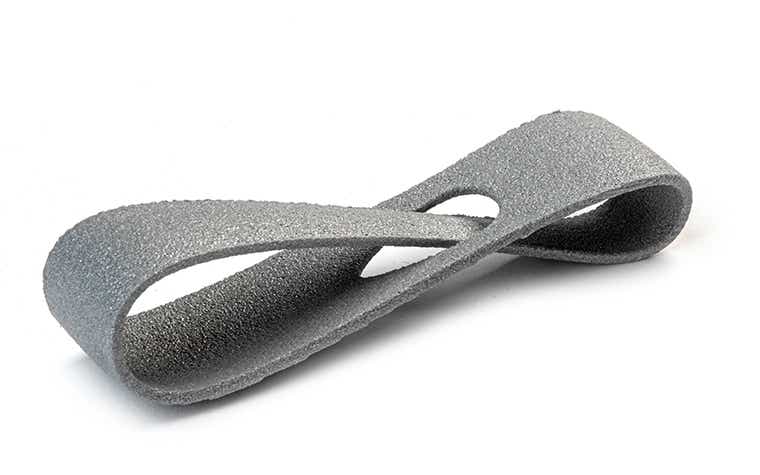 Un lazo gris brillante impreso en 3D hecho de PA-AF (relleno de aluminio) mediante sinterización láser, acabado con un sellador.