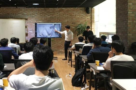 Group of people sitting in a room to learn about metal 3D printing