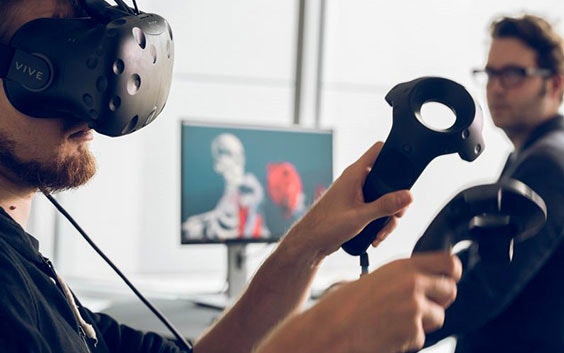 3D 계획 소프트웨어가 설치된 컴퓨터 화면에서 다른 사람 앞에서 VR 도구를 사용하는 남성