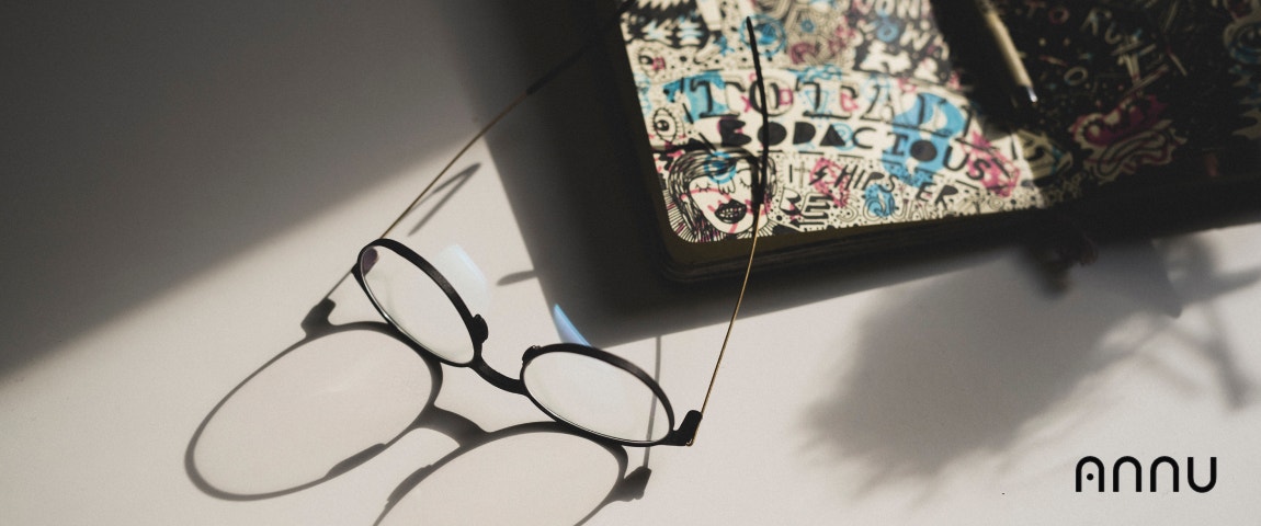 3D-gedruckte Brille, die auf einem dekorierten Stück liegt und deren Schatten sich auf dem Boden spiegelt