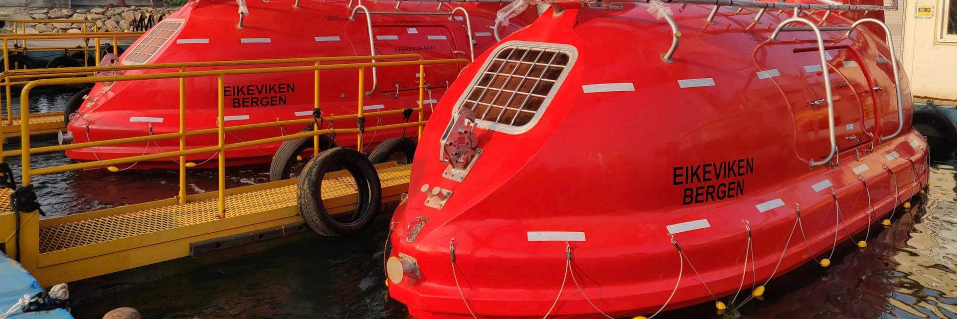 Two red lifeboats docked