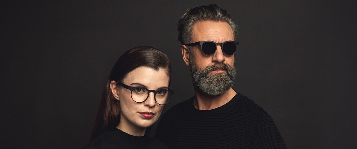 Male and female models in black on a black background wearing Morrow Optics eyewear