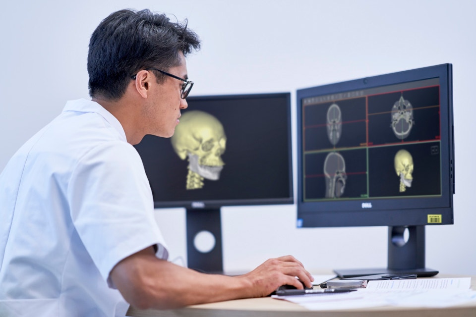 Healthcare professional reviewing skull scans in healthcare software