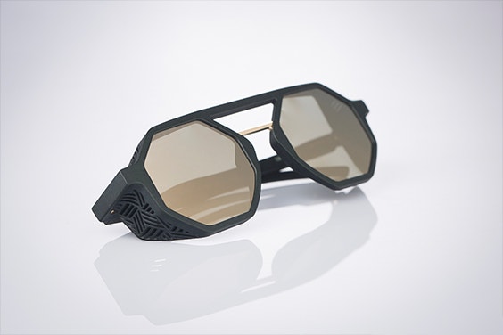 Side, angled view of da27xLasnik sunglasses, folded up on a white surface