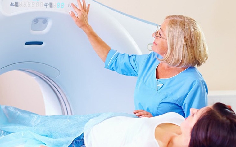 A woman and a patient in a CT scan.
