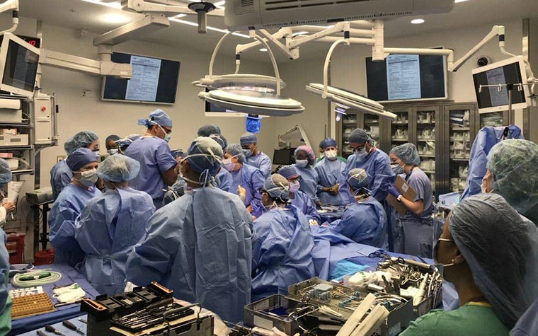 A team of surgeons and clinicians in an operating room rehearsing the surgical procedure 