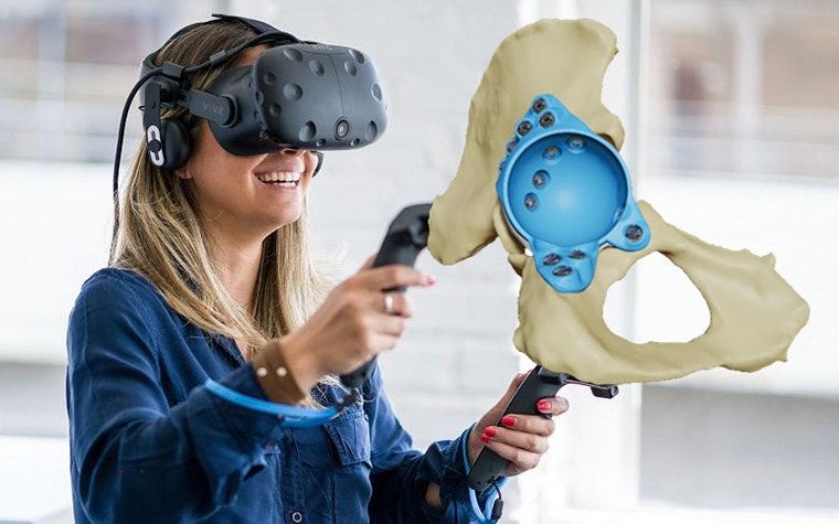 Woman smiling and handling a hip with an implant using virtual reality 