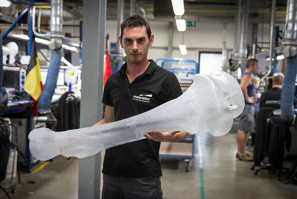 Materialise employee holds large 3D-printed bone, measuring over one meter long 
