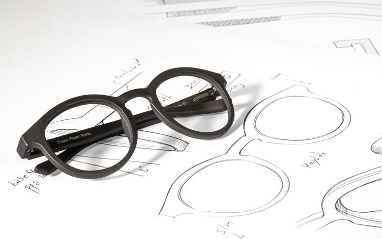 Black 3D-printed eyewear atop sketches. Credit: Odette Lunettes.