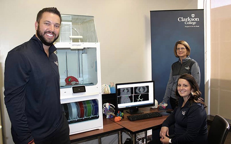 Clarkson College faculty members next to 3D printing setup 