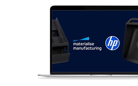 A laptop screen showing the HP and Materialise Manufacturing logos next to each other with a couple of 3D prints on either side