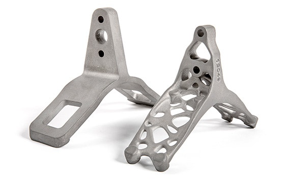 Side-by-side comparison of 3D-printed titanium lift brackets. One is solid and the other has an optimized design with holes