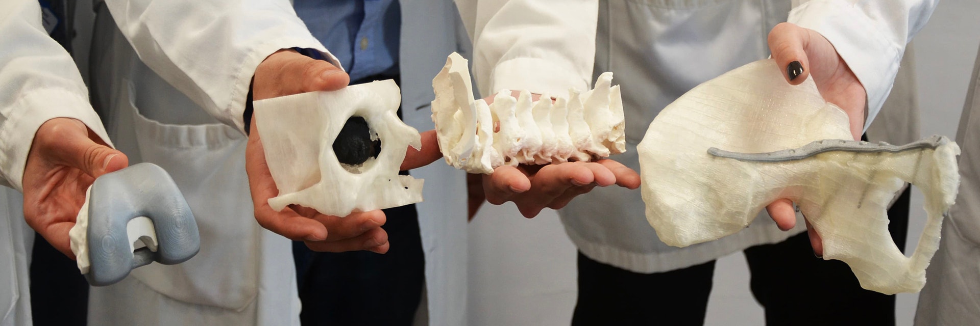 3D printing team members holding 3D-printed anatomical models 