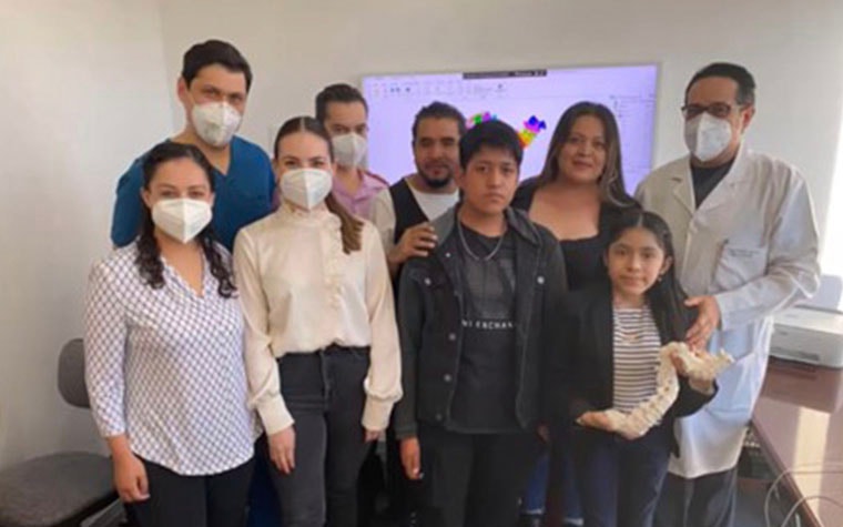 Group of people wearing face masks and posing with the doctor and patient