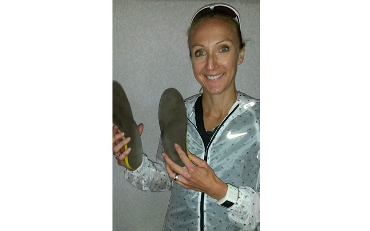 Runner Paula Radcliffe smiling and posing while holding her phits insoles