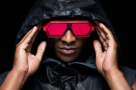Modelo masculino negro sosteniendo unas gafas rojas de VAVA Red Label en su cara
