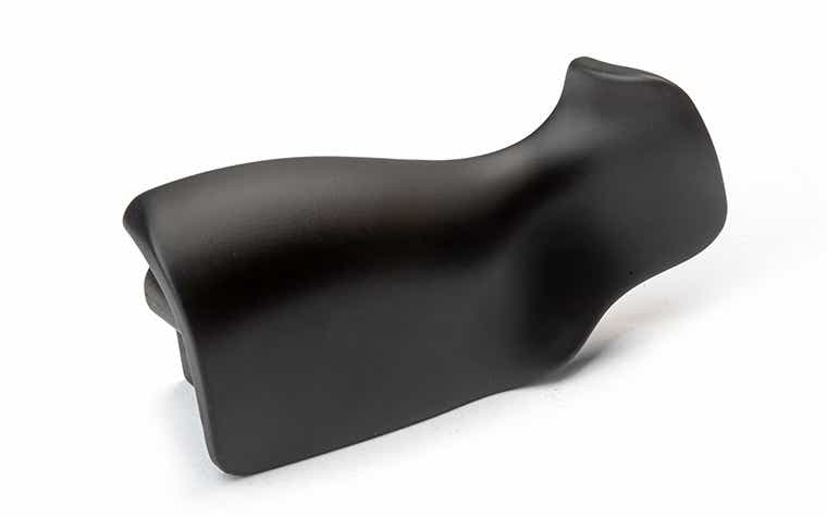 Une poignée noire mate fabriquée avec des polyuréthanes de type ABS par moulage sous vide, finie avec un apprêt et une peinture soft-touch.