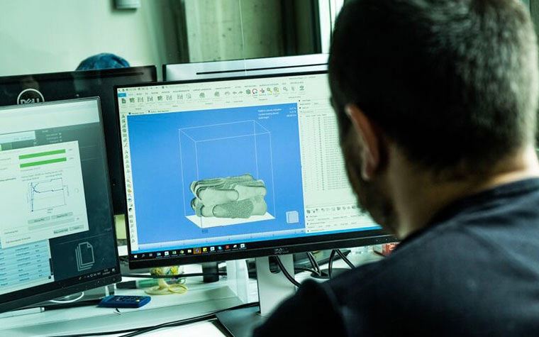 Man looking at a computer screen, preparing insoles to be 3D printed