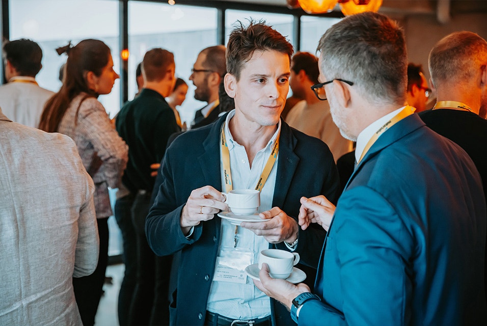 Two Materialise CMF Innovation Summit attendees holding coffes and chatting