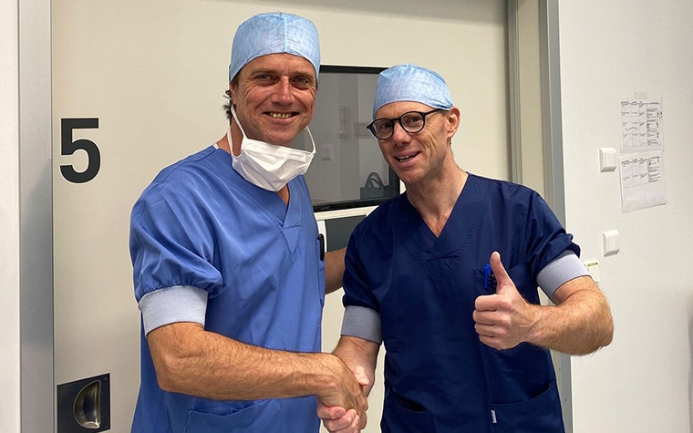 Dr. Philippe Van Overschedulde shaking hands with a Materialise sales representative while smiling and giving a thumbs up