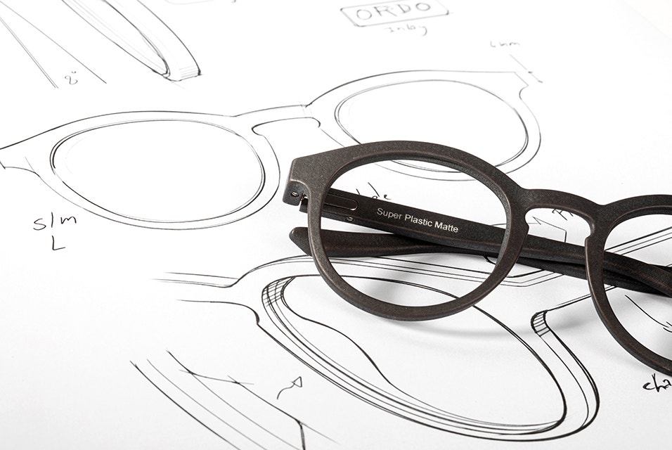 3D-printed eyewear frames lying on top of a eyewear design drawing