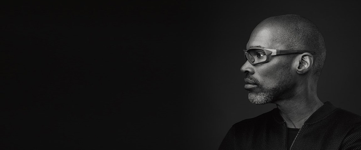 Profile view of a black male model in gray-scale wearing Seiko Xchanger eyewear