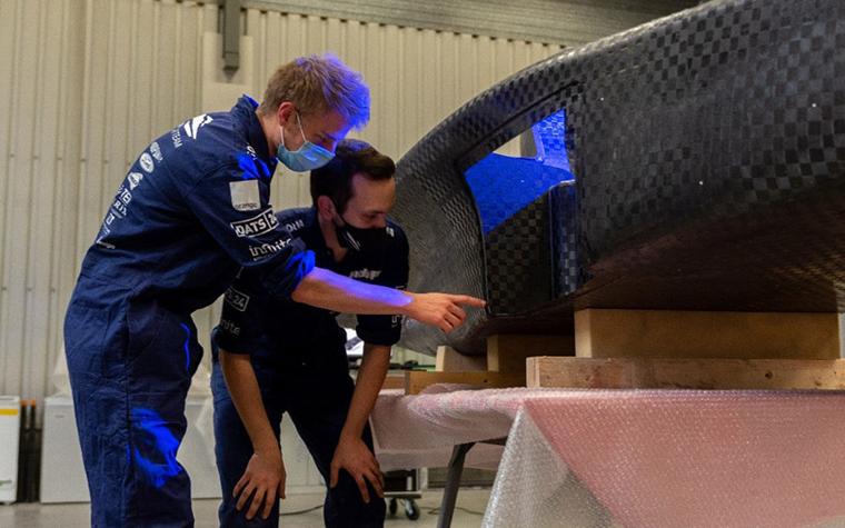 Two solar car team members looking at a part