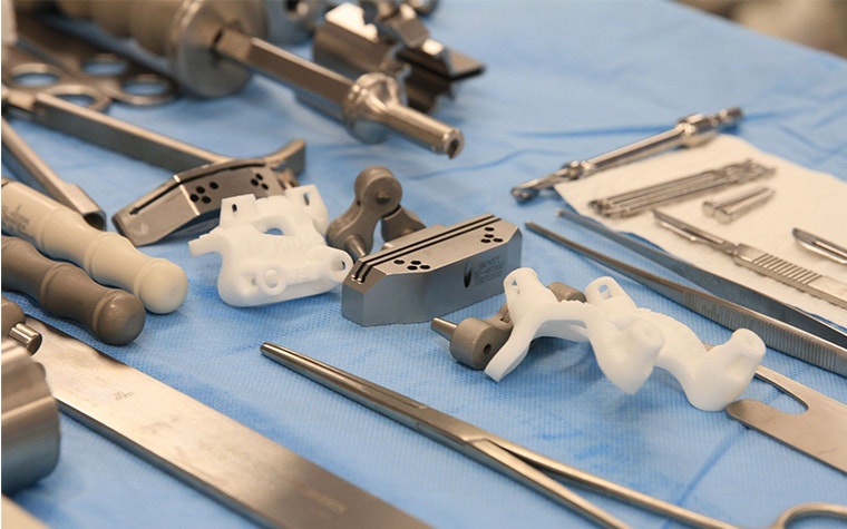 Surgical tools, including 3D-printed surgical guides, on a lined plate before a surgery