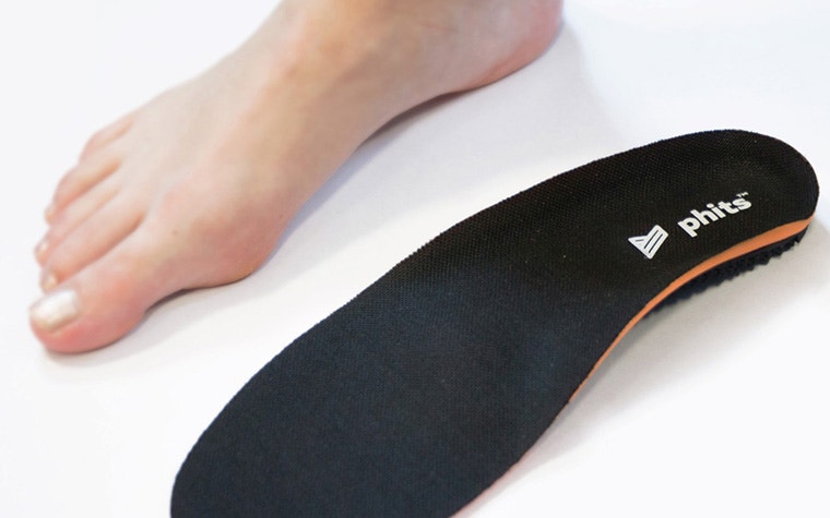 Close up of a bare foot side by side with a 3D-printed phits orthotic insole