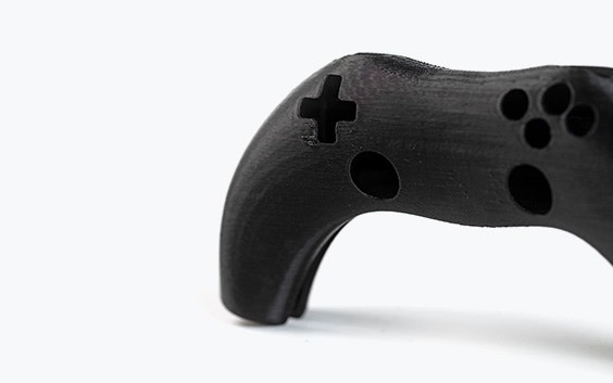 Un controlador de videojuego impreso en 3D en color negro, impreso en ABS-ESD7 mediante modelado por deposición fundida.
