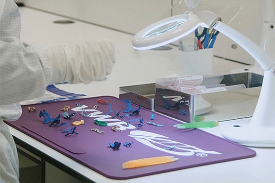 Personal handling various medical parts on a work table.