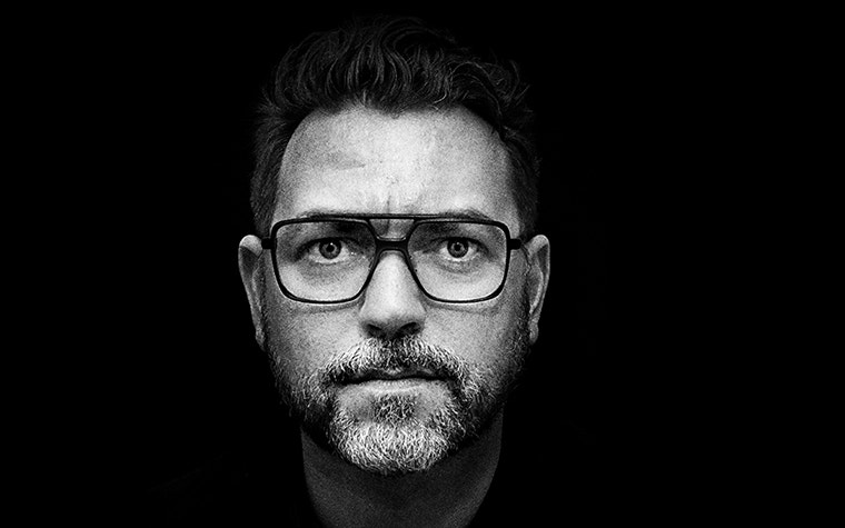 Grey-scale, extreme close-up image of bearded male model wearing fmhofmann eyewear