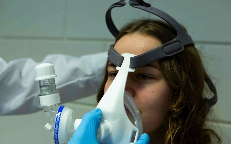 Oxygen mask with 3D-printed components being placed on a patient