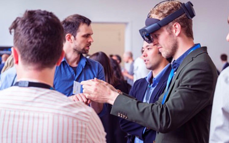 Man wearing a VR headset in a crowd of people at the 3D Printing in Hospitals Forum 2022