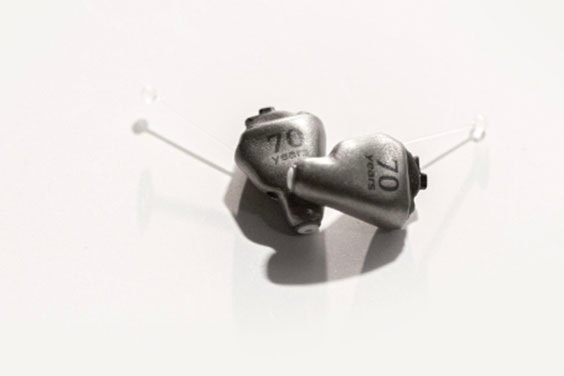 Metal 3D-printed hearing aids with '70 years' etched in the material