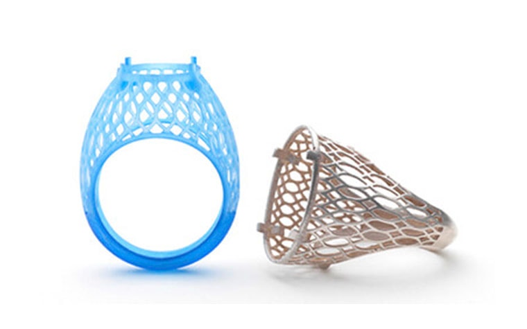 Plastic 3D-printed prototype of a ring next to the final version printed in metal